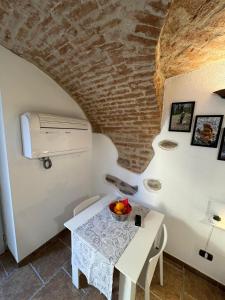 a dining room with a white table and a brick wall at Ca' D'Rosina in Narzole