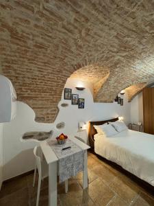 a bedroom with a bed and a table and a brick wall at Ca' D'Rosina in Narzole