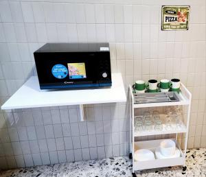 eine Mikrowelle, die auf einem Regal in einer Küche steht in der Unterkunft Luna di Pisa in Pisa