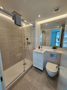 um banheiro com chuveiro, vaso sanitário e pia em Luxury studio in Gibraltar em Gibraltar