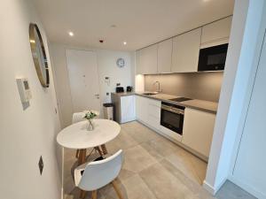 uma cozinha com uma mesa e duas cadeiras e uma mesa em Luxury studio in Gibraltar em Gibraltar