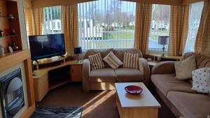 Una sala de estar con un sofá y un televisor. en Oscar's Retreat, en Winthorpe