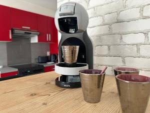 eine Kaffeemaschine auf einem Tisch mit zwei Tassen in der Unterkunft Le Manet, Lagny-sur-Marne in Lagny