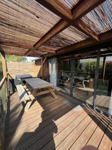 a wooden deck with a picnic table and a wooden pergola at 508 Mobilhome tout confort in La Teste-de-Buch