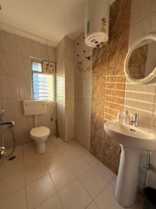a bathroom with a toilet and a sink at Bela D Casa - 3BHK overlooking mountains and city in Guwahati +36 photos