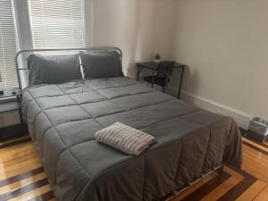 ein Bett in einem Schlafzimmer mit einer Decke drauf in der Unterkunft Homestay Near South Bay Mall & Andrew Train Station in Boston