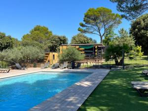 a swimming pool in a yard with a house at Les Troglodytes du Ventoux in Bollène