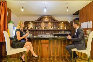 a man and a woman sitting at a bar at FabHotel Pentagon Next - Bhubaneswar Railway Station in Bhubaneshwar