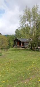 a log cabin in the middle of a grass field at Cabañas Kuyen in Coihaique
