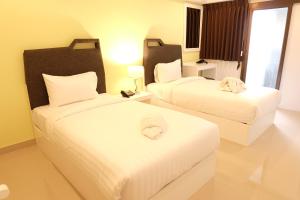 a hotel room with two beds with white sheets at Sunny Residence in Lat Krabang