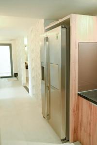 Kon Rung (1)Swan Suite Villa Đà Lạt的空荡荡的厨房里摆着一台不锈钢冰箱。