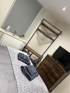 a bedroom with a bed with a mirror and a dresser at Erskine Apartment-Small and Cosy 1 Bedroom Apartment in Angus