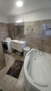 a bathroom with a tub and a toilet and a sink at Steffi Apartment in Balş