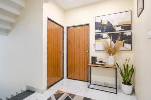 a hallway with two wooden doors and a table at FabHotel Atharv in Indore