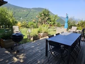 ブリッド・レ・バンにあるChalet La Hulotteのテーブル付きのデッキのバーベキューグリル