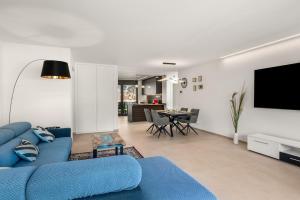 a living room with a blue couch and a tv at Terrace, Garden & Castle View in Bellinzona