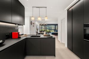 a kitchen with black cabinets and a red appliance at Terrace, Garden & Castle View in Bellinzona +14 photos
