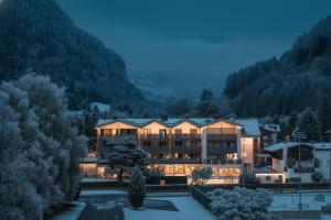 a large building in the middle of a mountain at Hotel WH - Wiesnerhof in Vipiteno