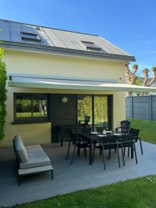 a patio with a table and chairs in front of a house at Les Alois 10 min to Disneyland in Couilly-Pont-aux-Dames