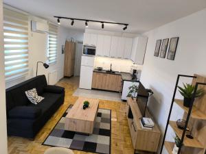a living room with a black couch and a table at Apartman Stefani in Pirot