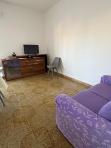 a living room with a purple couch and a cabinet at A pantanello da Nuzzo in Avola