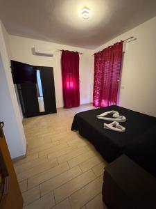 a bedroom with a black bed and red curtains at A pantanello da Nuzzo in Avola