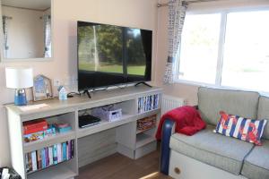 a living room with a television on a entertainment center at Clearsands at Haven in Mablethorpe