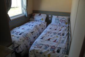 two twin beds in a small bedroom at Clearsands at Haven in Mablethorpe