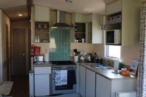 a small kitchen with a stove and a sink at Clearsands at Haven in Mablethorpe