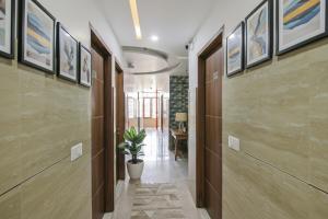 a hallway with paintings on the walls and a potted plant at FabHotel Meridian Inn in Mohali