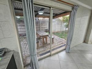 a screened in porch with a table and a bench at Sally's Place in Boksburg