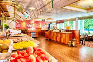 a buffet line with fruit on trays in a restaurant at Leonardo Hotel Hamburg City Nord in Hamburg