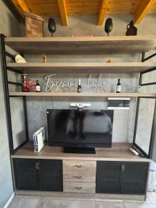 ein Entertainment-Center mit einem Fernseher in einem Zimmer in der Unterkunft Wine Studio with BBQ & pool in Las Heras