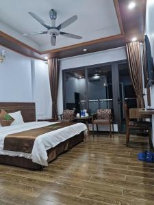 a bedroom with a large bed with a ceiling fan at Khách sạn Rosalia in Tam Ðảo