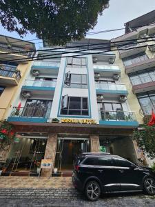 a black car parked in front of a building at Khách sạn Rosalia in Tam Ðảo +11 photos