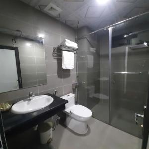 a bathroom with a toilet and a sink and a shower at Khách sạn Rosalia in Tam Ðảo