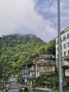 a building with a mountain in the background at Khách sạn Rosalia in Tam Ðảo