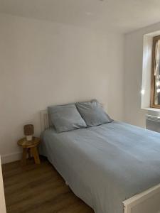 a bedroom with a bed with blue sheets and a table at Charmant T2 cosy à Mazamet in Mazamet