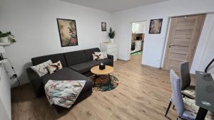a living room with a couch and a table at Xela Apartment in Sklenárovo
