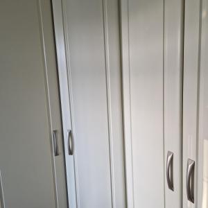 a pair of white cabinets with silver handles at Single Bedroom in the main Bungalow in Wednesfield
