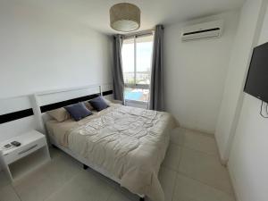 ein kleines Schlafzimmer mit einem Bett und einem Fenster in der Unterkunft Altos Del Plata 105 y 505 Colonia Uruguay in Colonia del Sacramento + 26 Fotos