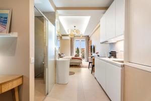 a kitchen with white cabinets and a dining room at Nice Renting - HUGO - Luxury Honeymoon Suite Terrace Park View Free Parking in Nice