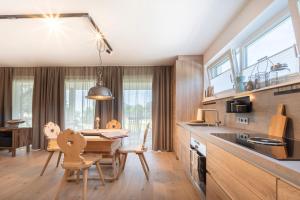 a kitchen with a table and chairs and a dining room at Apartment mit rundum Blick in die Berge in Faistenau