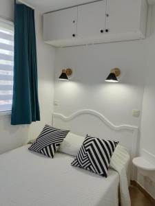 a bedroom with a bed with two pillows on it at Appartement Belle vue mer, au calme avec climatisation et wifi 4 personnes in Grimaud