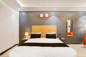 a bedroom with a large white bed and two lamps at Super Hotel O Golden Tulip'z in Gorakhpur