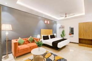 een slaapkamer met een bed en een bank bij Super Hotel O Golden Tulip'z in Gorakhpur