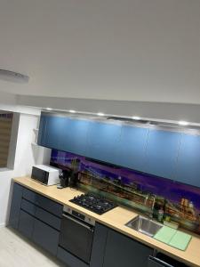 a kitchen with blue cabinets and a counter top at Privilege in Tecuci +3 photos