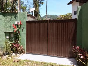 a wooden gate in front of a house at Chalé da Sheila in São Sebastião
