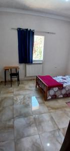 a room with a bed and a table and a window at Hostel 1er novembre khenchela in Khenchela