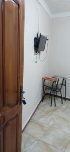 a room with a table and a tv on a wall at Hostel 1er novembre khenchela in Khenchela